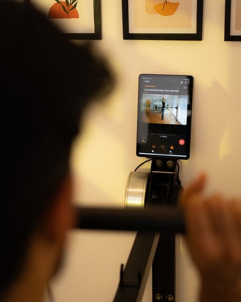 The Ferra app on the machine's screen guiding an Overhead Shoulder Press, with the rep counter and weight